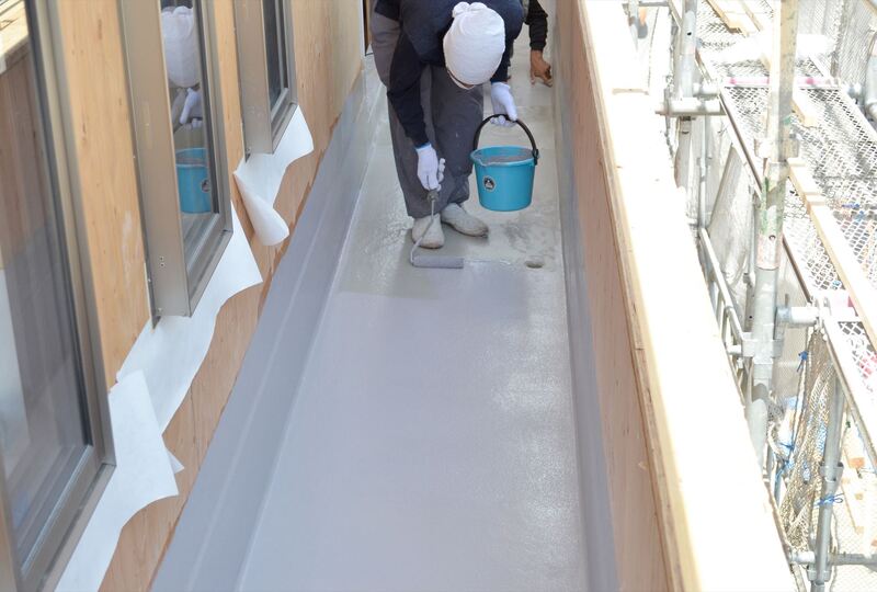 ベランダ床の防水工事を行う職人jpg